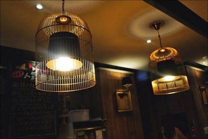 開朗猶愛收銀台上頭的鳥籠燈飾，覺得藉由像小欄杆的外牆散發出來的黃光挺柔和舒服。