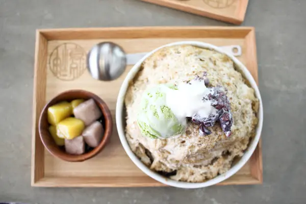 神仙草的特色之一就是用仙草做的雪花冰.雪花冰幾乎不會融化只會慢慢變深色 原來秘訣在於雪花冰不加奶粉而且使用日本機器打成較為蓬鬆